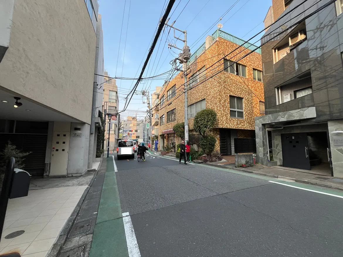 日本の都市風景、狭い道路、歩行者と自転車、異なるデザインの住宅と建物