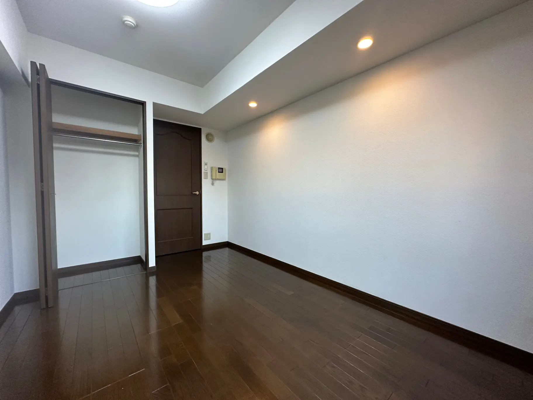 明るい照明が印象的なシンプルな部屋、広々としたクローゼット付き
