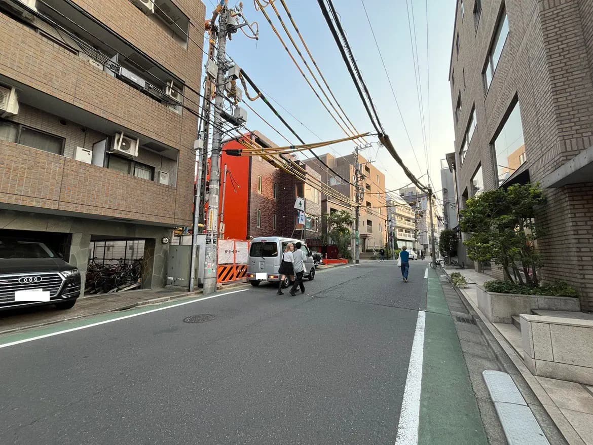 都市の日常風景、建物、配電線、歩行者、走行中の車