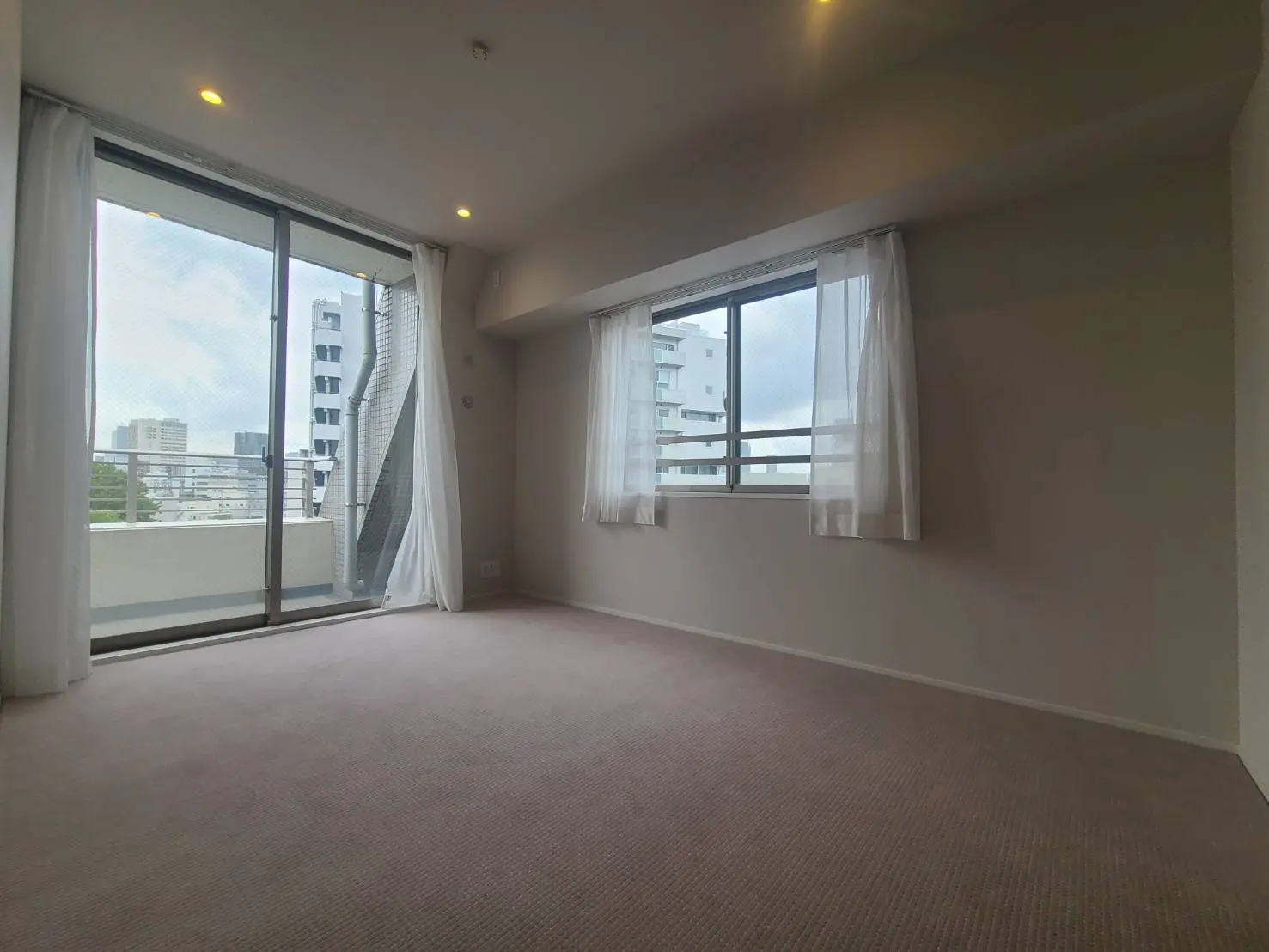 - 明るい自然光が差し込むシンプルなモダンな部屋、白いカーテンと大きな窓が特徴のインテリア
