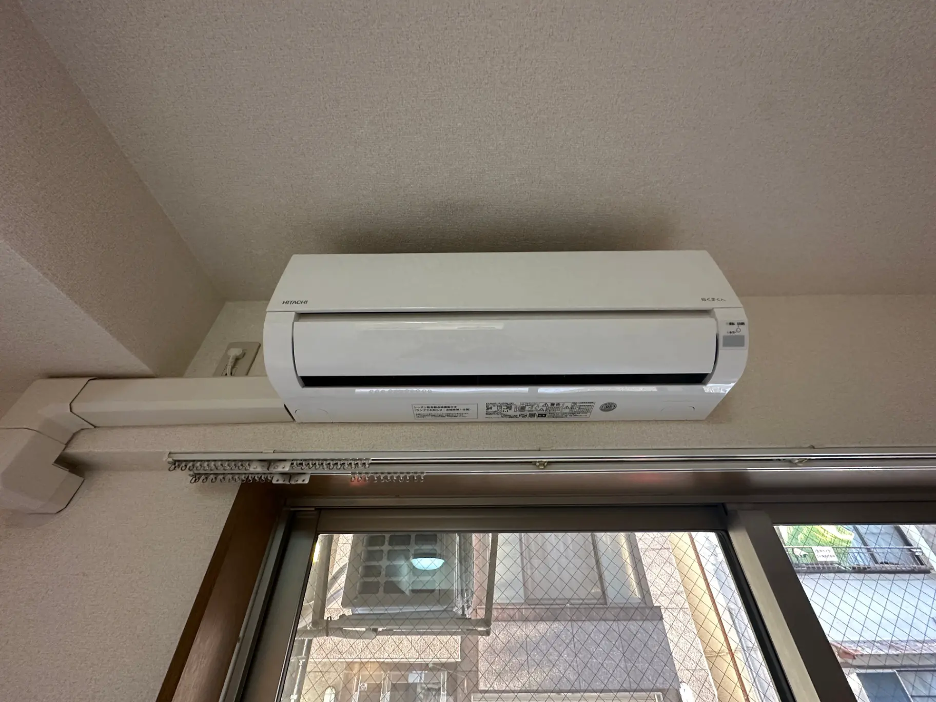 エアコン付きの室内と窓越しの光が差し込む明るい部屋