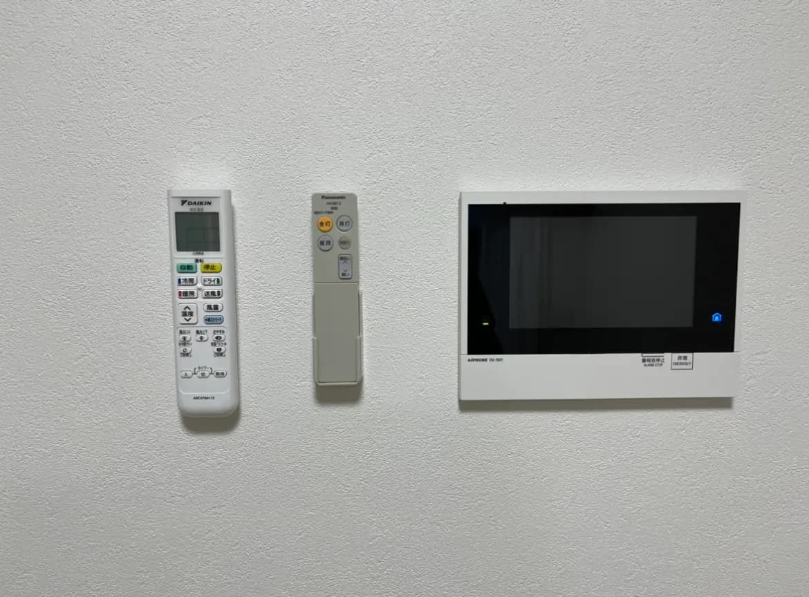 空調のリモコンとホームオートメーションシステムのタッチパネルが壁に取り付けられているインテリア