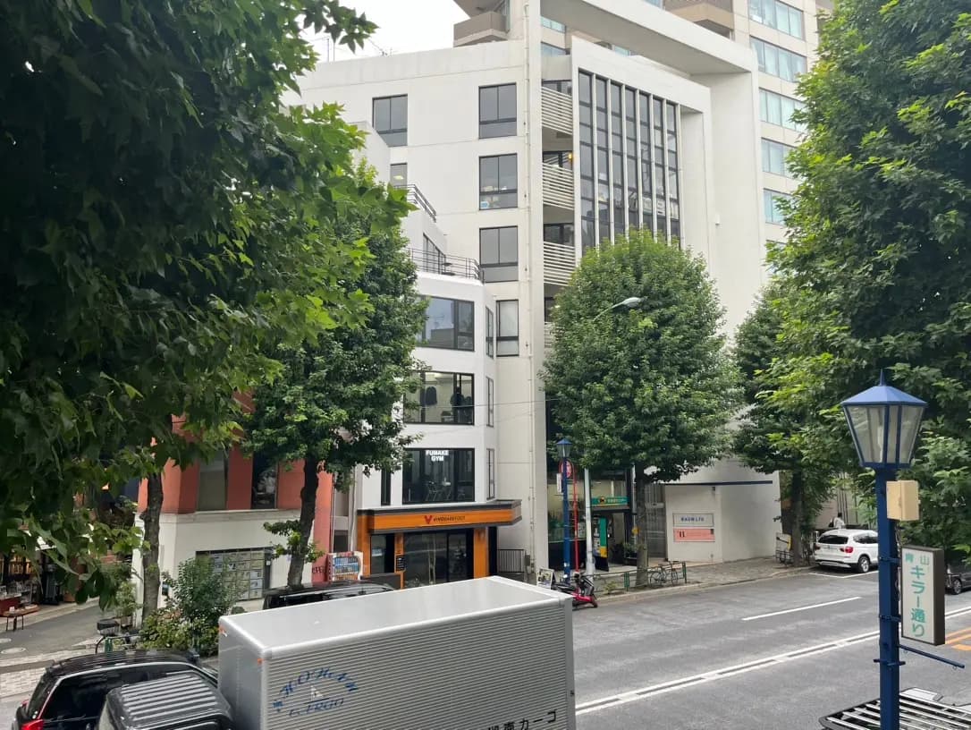 都市の風景、緑の木々、モダンな建物と店舗、日中の静かな通り