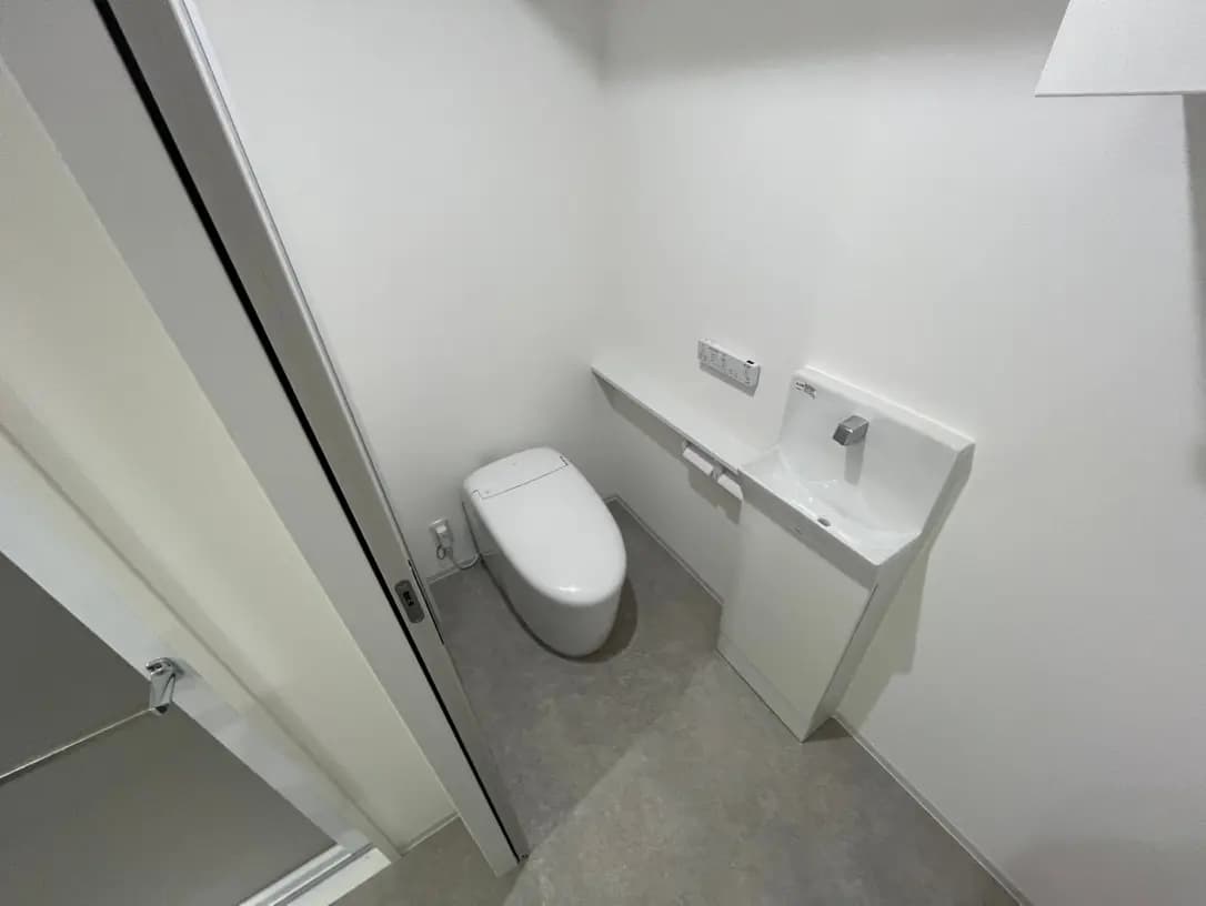 シンプルなデザインのトイレと手洗い器、清潔でモダンなバスルームインテリア