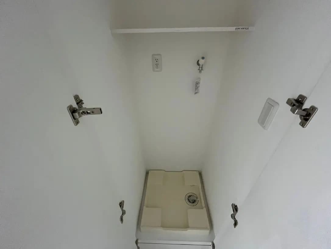 日本のトイレの洗浄便座と壁に取り付けられたタオルハンガー、清潔感のある白い壁