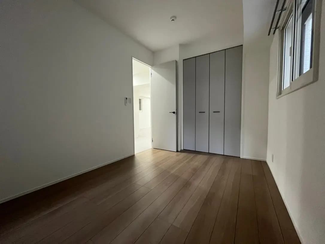 シンプルなデザインの空の部屋、木製フローリング、白い壁、クローゼット付き