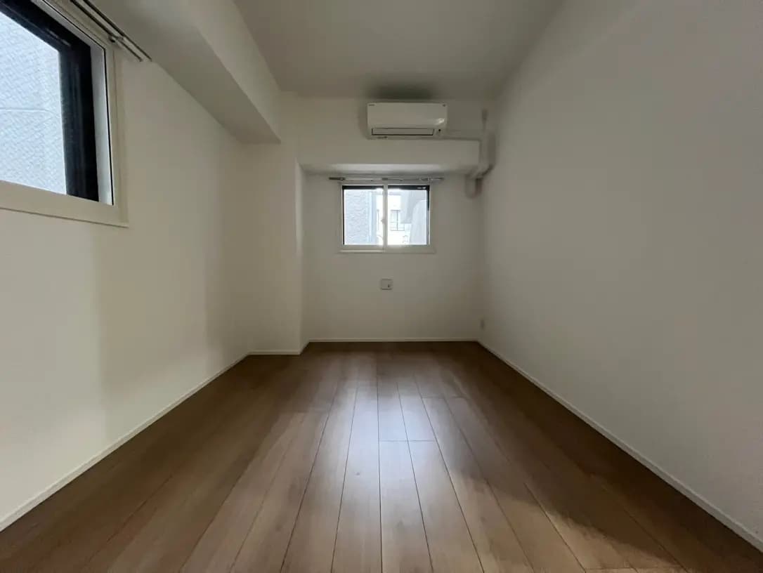 シンプルなデザインの空の部屋、エアコン付き、小さな窓から自然光が差し込む