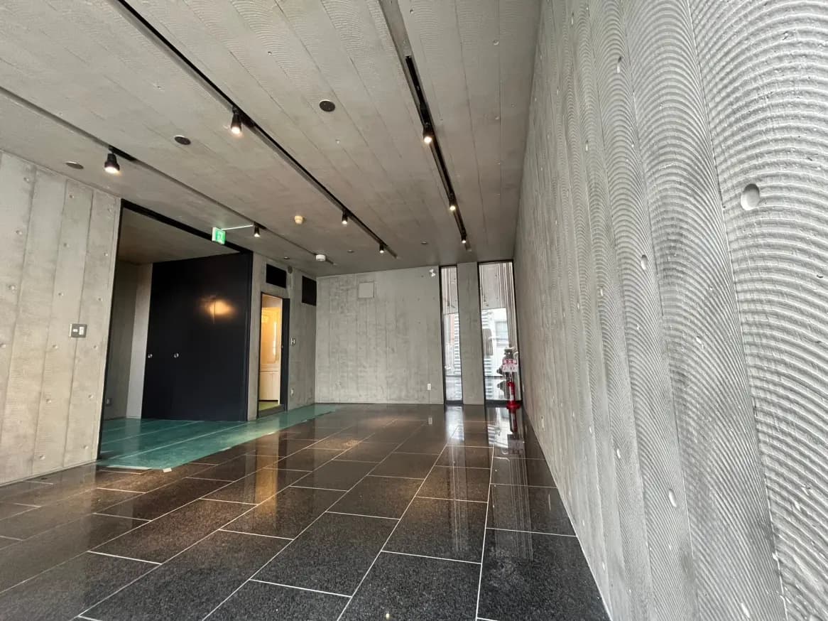 モダンな建築スタイルの屋内ロビー、コンクリートとガラスの壁、洗練された照明とタイルフローリング