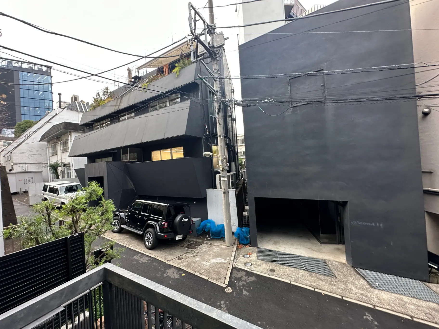 現代的なデザインの黒い建物の外観、都市の路地に駐車された車