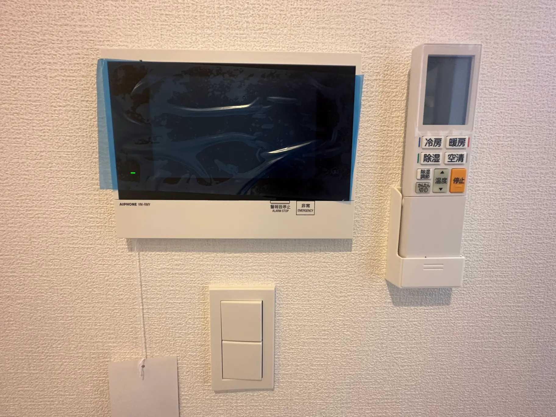壁掛け式インターホンと複数のボタンが付いた住宅のセキュリティシステムパネル