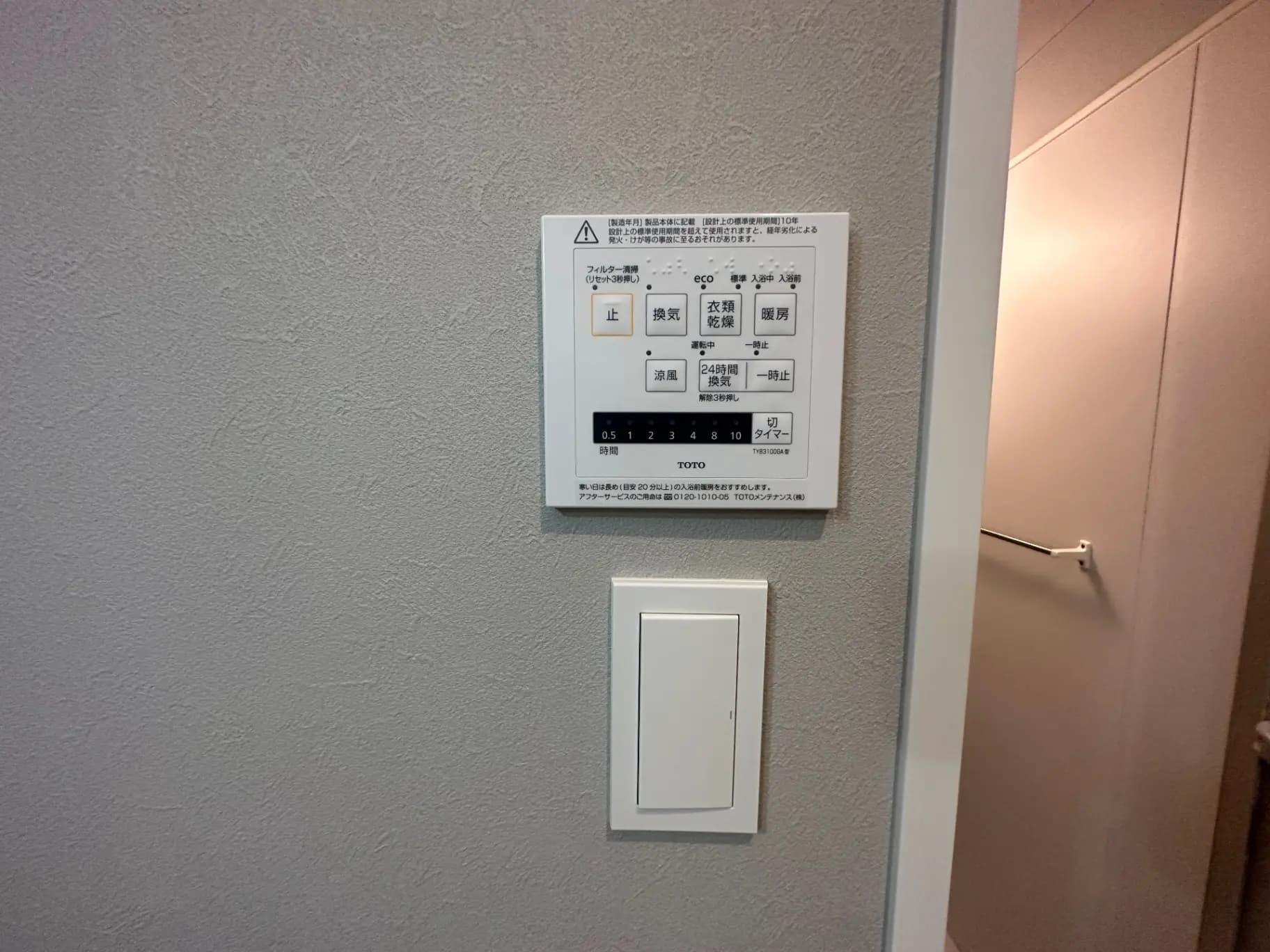 建物内の壁に取り付けられた省エネルギー管理システム操作パネル、注意喚起の表示と隣接するスイッチ