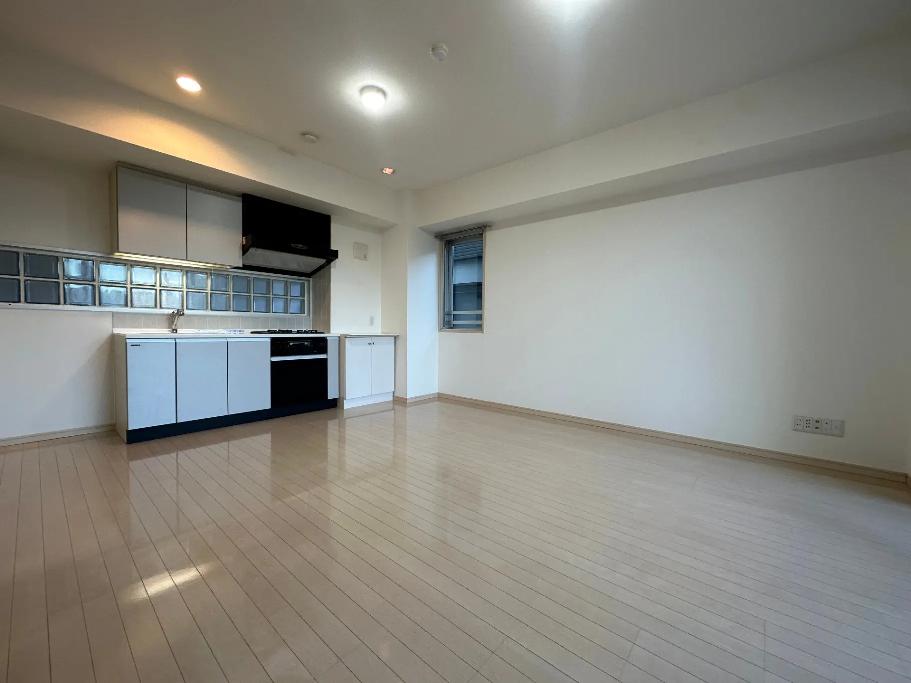 明るい照明の下のモダンなデザインのキッチンと広々としたリビングスペース