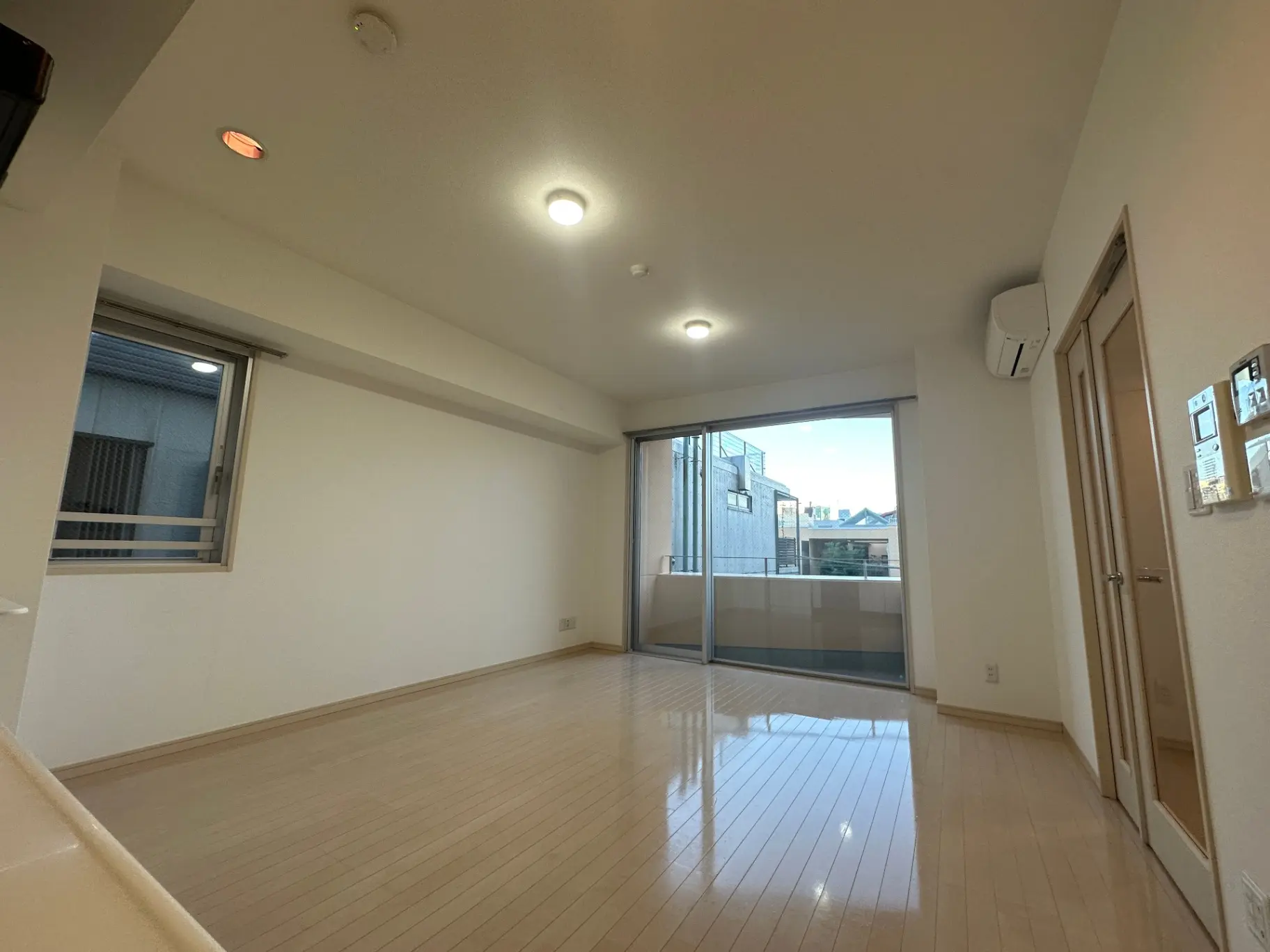 広々とした明るいリビングルーム、天井埋め込み型照明器具、大きな窓とバルコニー付き