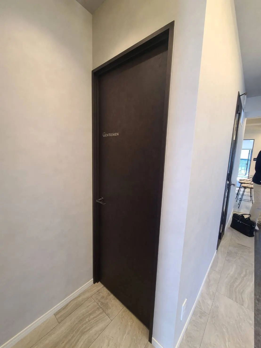 モダンな建物内の紳士用トイレのドア、落ち着いたカラー、明るい廊下