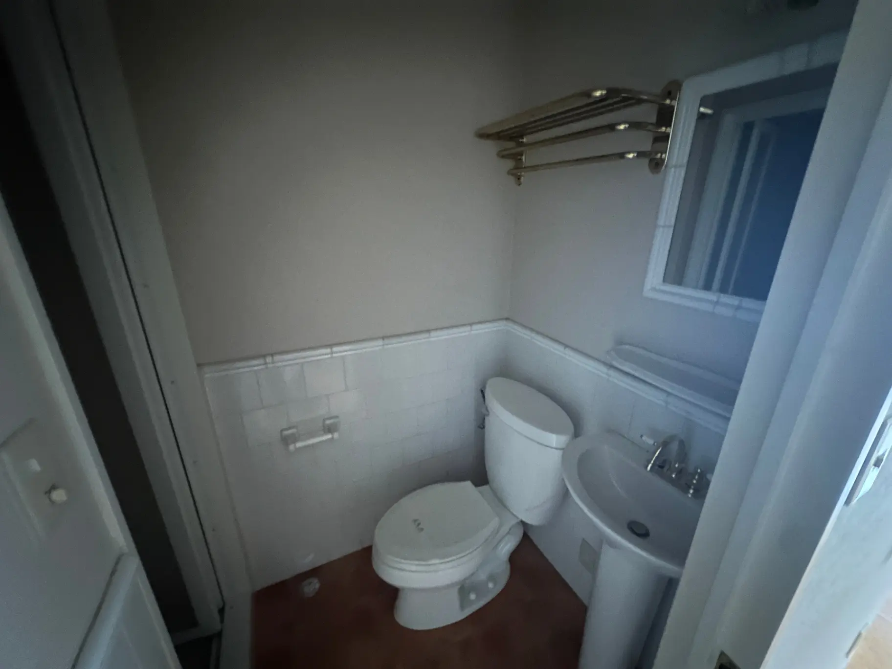 コンパクトなトイレと洗面台、窓付きで明るいバスルームのインテリア