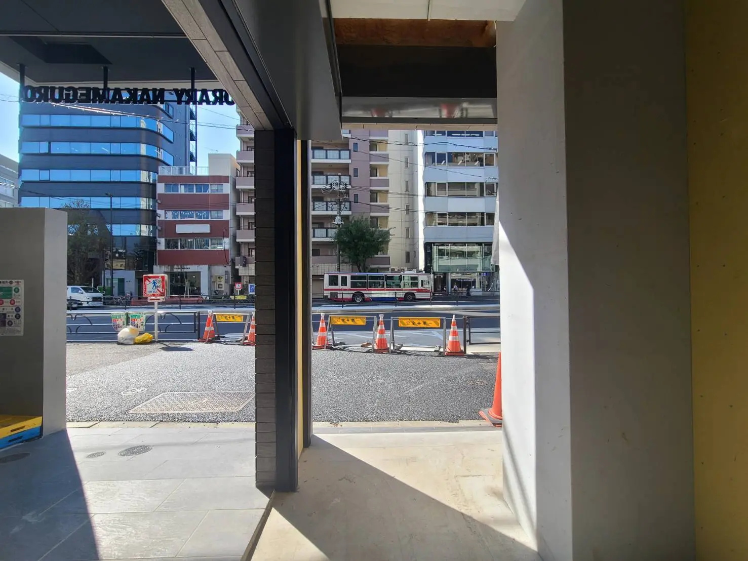 建設中の新ビルから見た都市の風景、通行止めの標識と作業中のコーン、晴れた日の都市交通