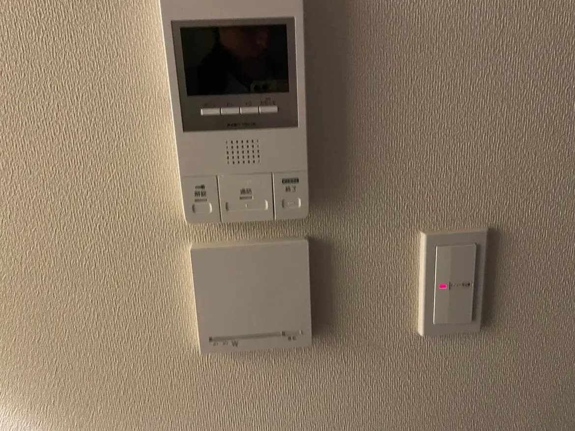 住宅のインターホンシステム、セキュリティセンサー、およびスイッチパネルが壁に設置されている室内の画像