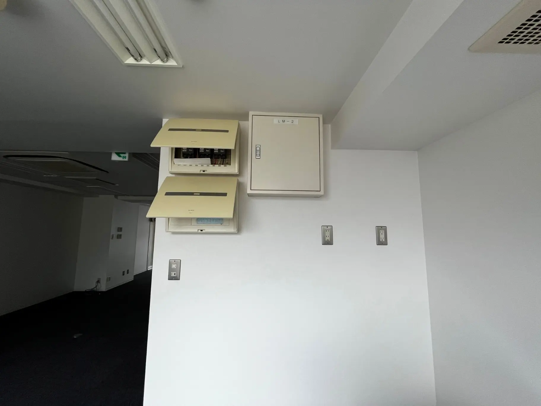 オフィスの配電盤と照明、電源コンセントが壁に設置されたモダンなオフィス空間
