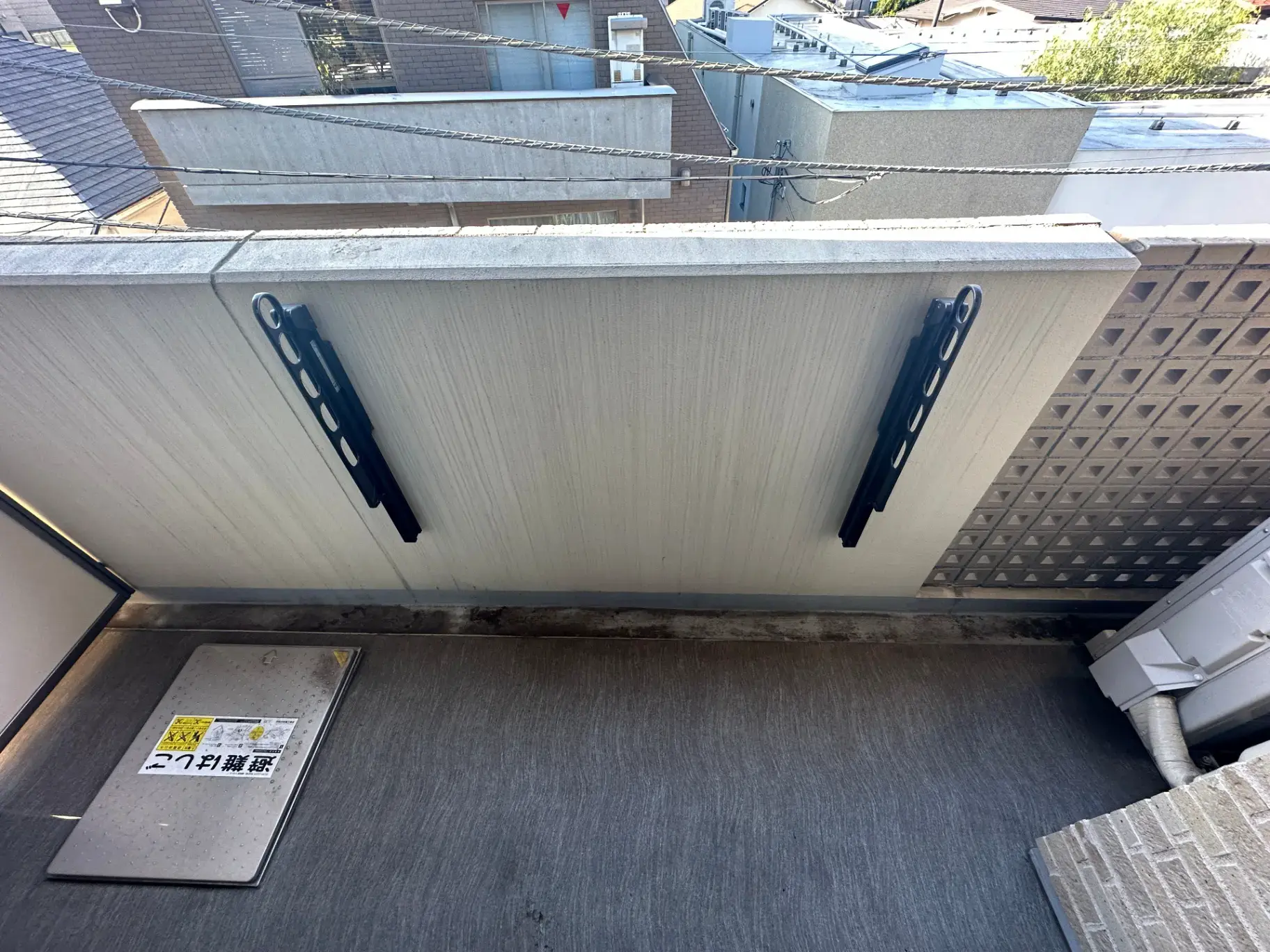 都市型住宅のベランダ、排水溝の保護カバー、風景と空、防犯カメラのステッカー付き