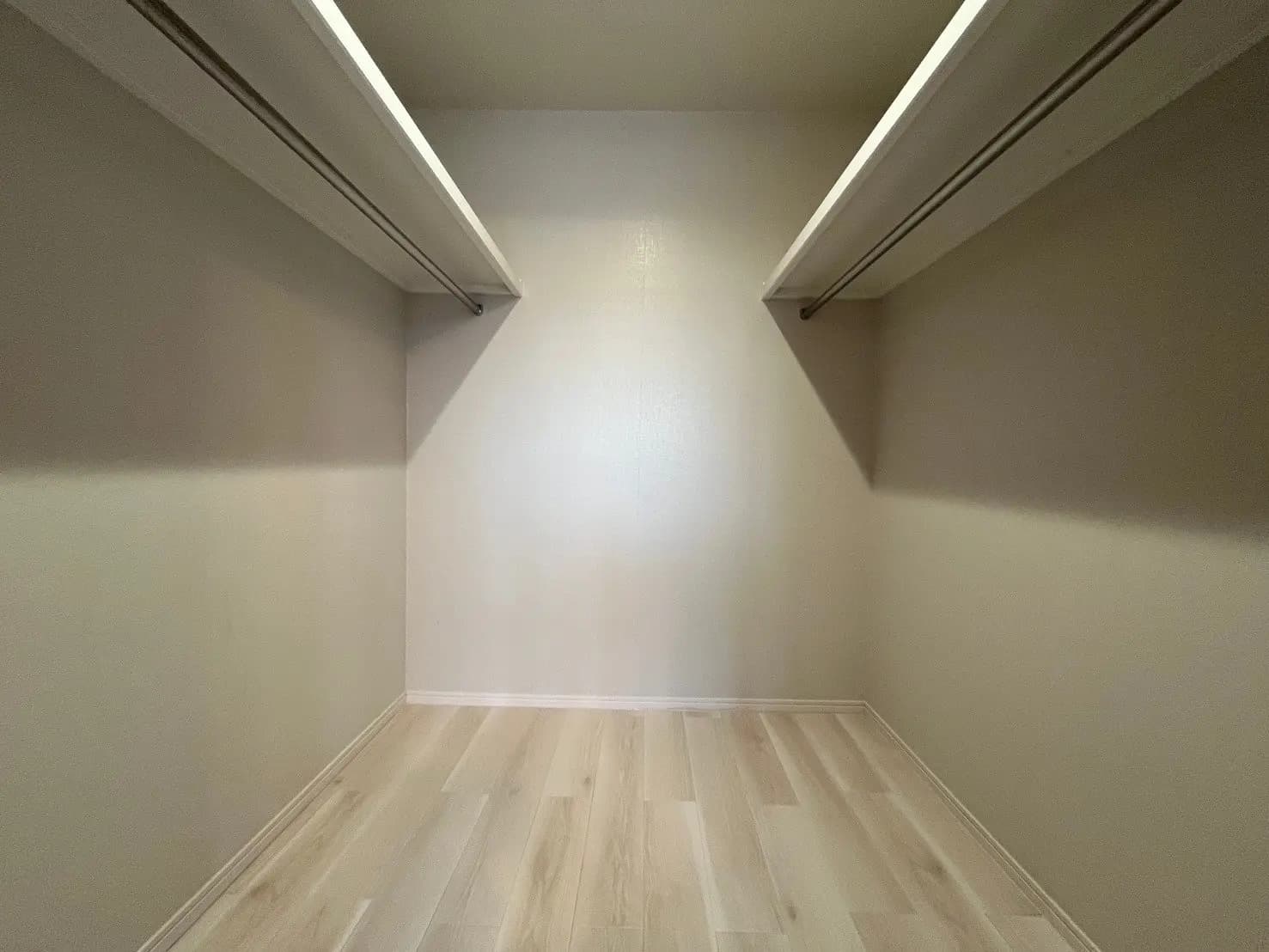 シンプルなデザインの空の部屋、天井に長い照明、木製の床