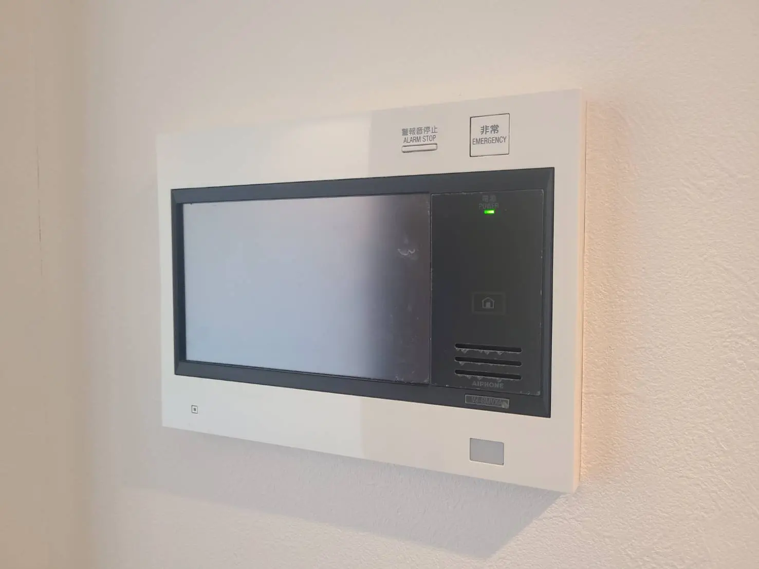 壁に取り付けられたモダンなインターホンシステム、緊急時止ボタンと電源表示ランプ付き