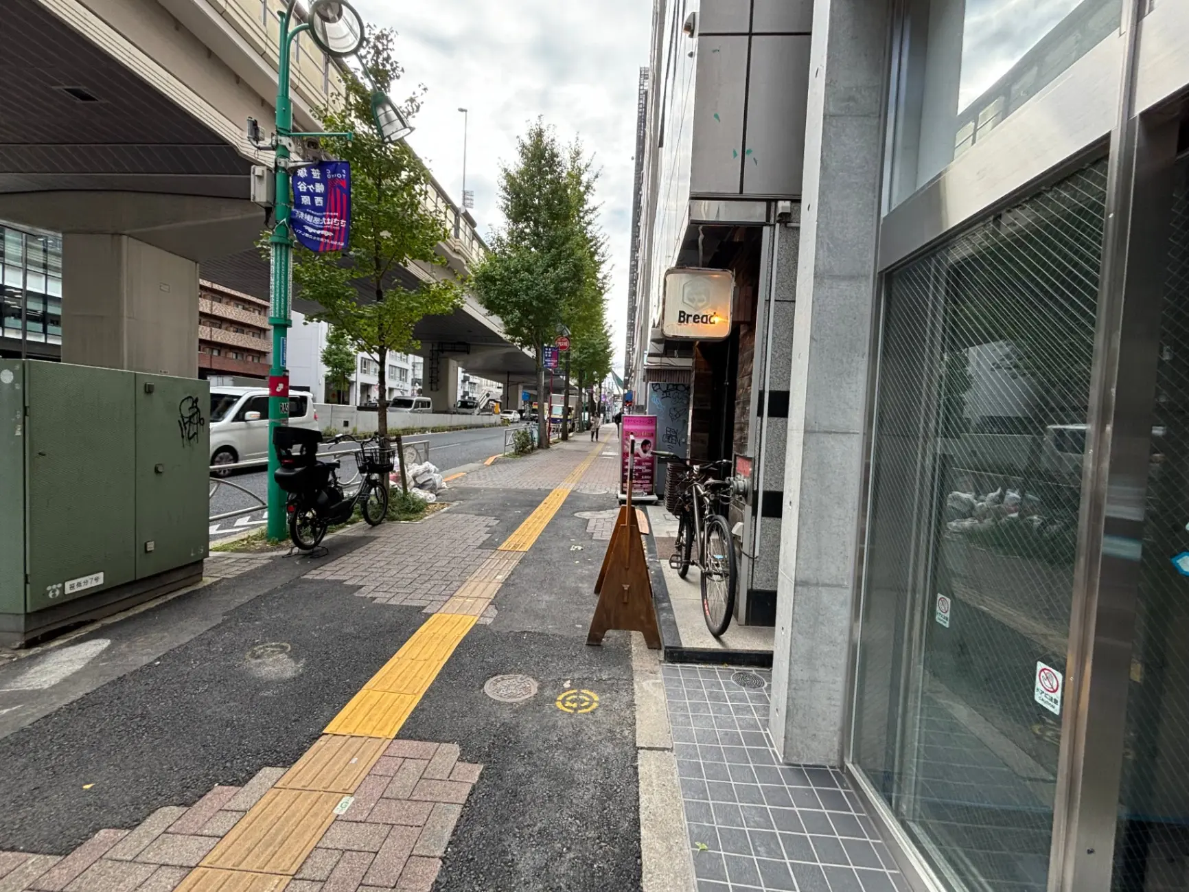 日本の都市部の歩道、自転車とオフィスビルが並ぶ通り、舗装された道路と都市インフラ