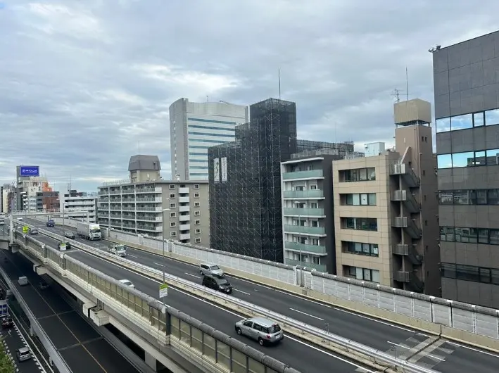 都市の高速道路と周辺のビル群、曇り空の下の日本の風景