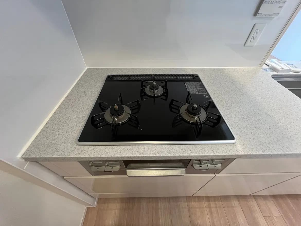 シンプルなデザインのキッチンコンロ、グレーのカウンタートップにブラックのビルトインガスストーブ
