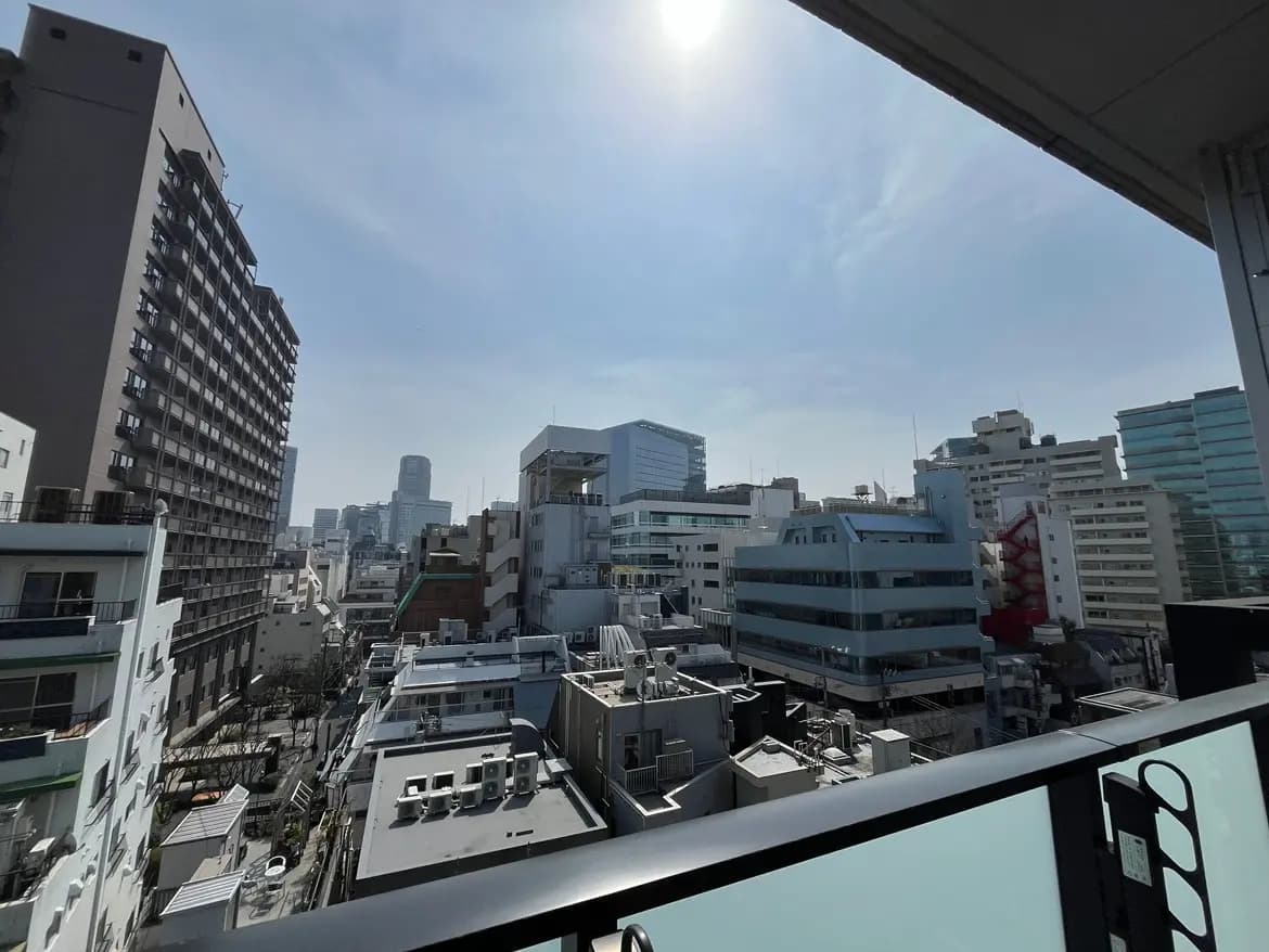 晴れた日の都会の風景、ビルと青空が見えるバルコニーからの眺望