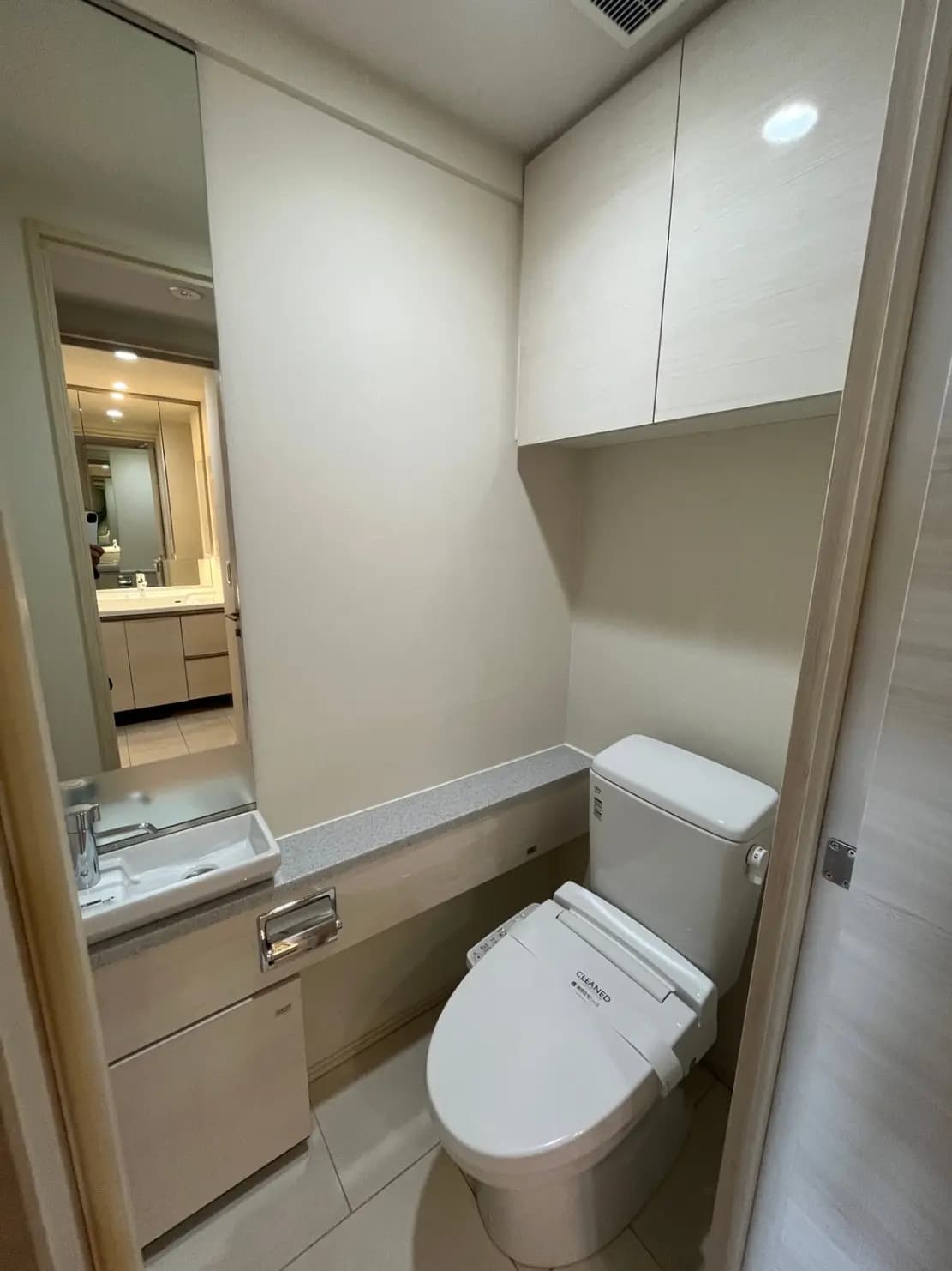 清潔でモダンなトイレと洗面台、ミラーキャビネット付きのコンパクトなバスルームデザイン
