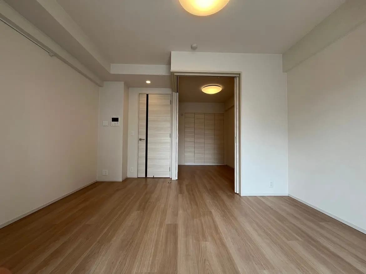 シンプルなデザインの空の部屋、木製フローリング、白い壁、天井の照明
