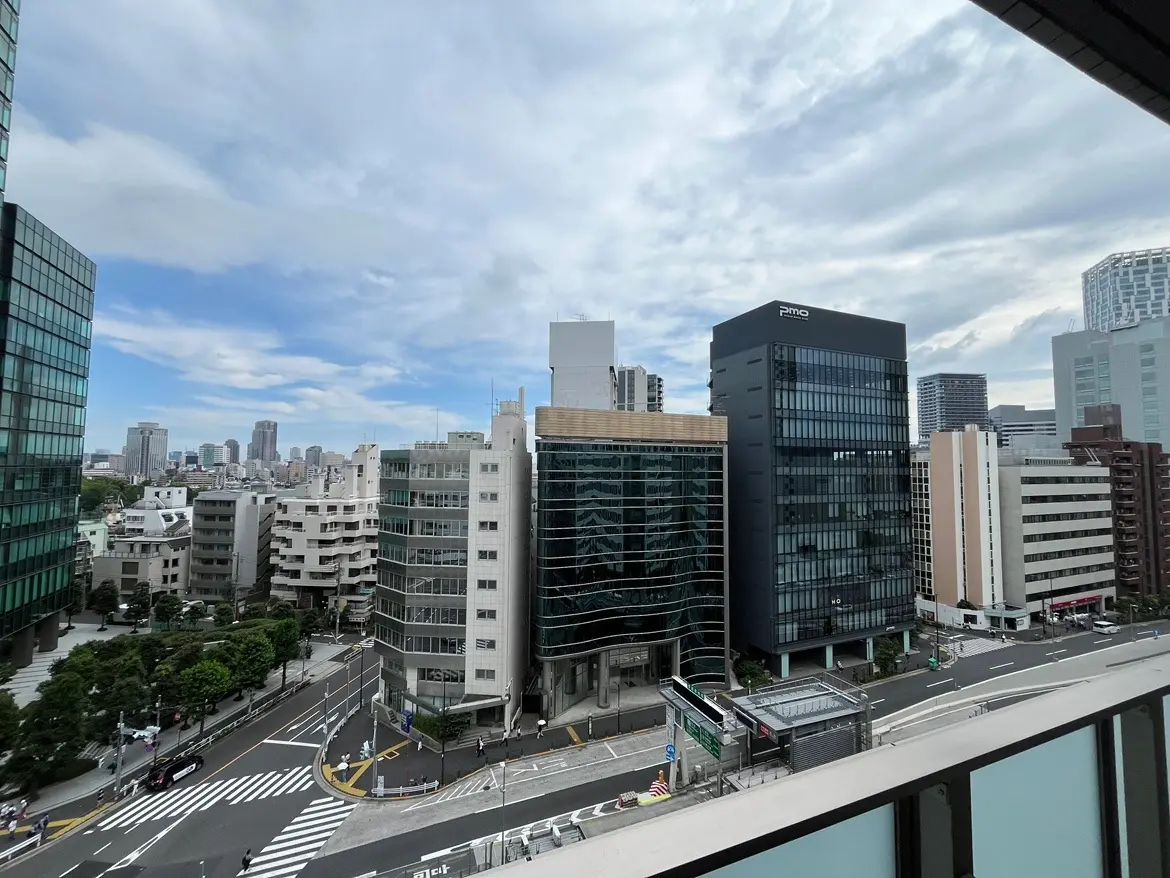 - 都市景観の展望、ビル群と青空が広がる風景、交差点と歩行者の様子が見えるサムネイル画像