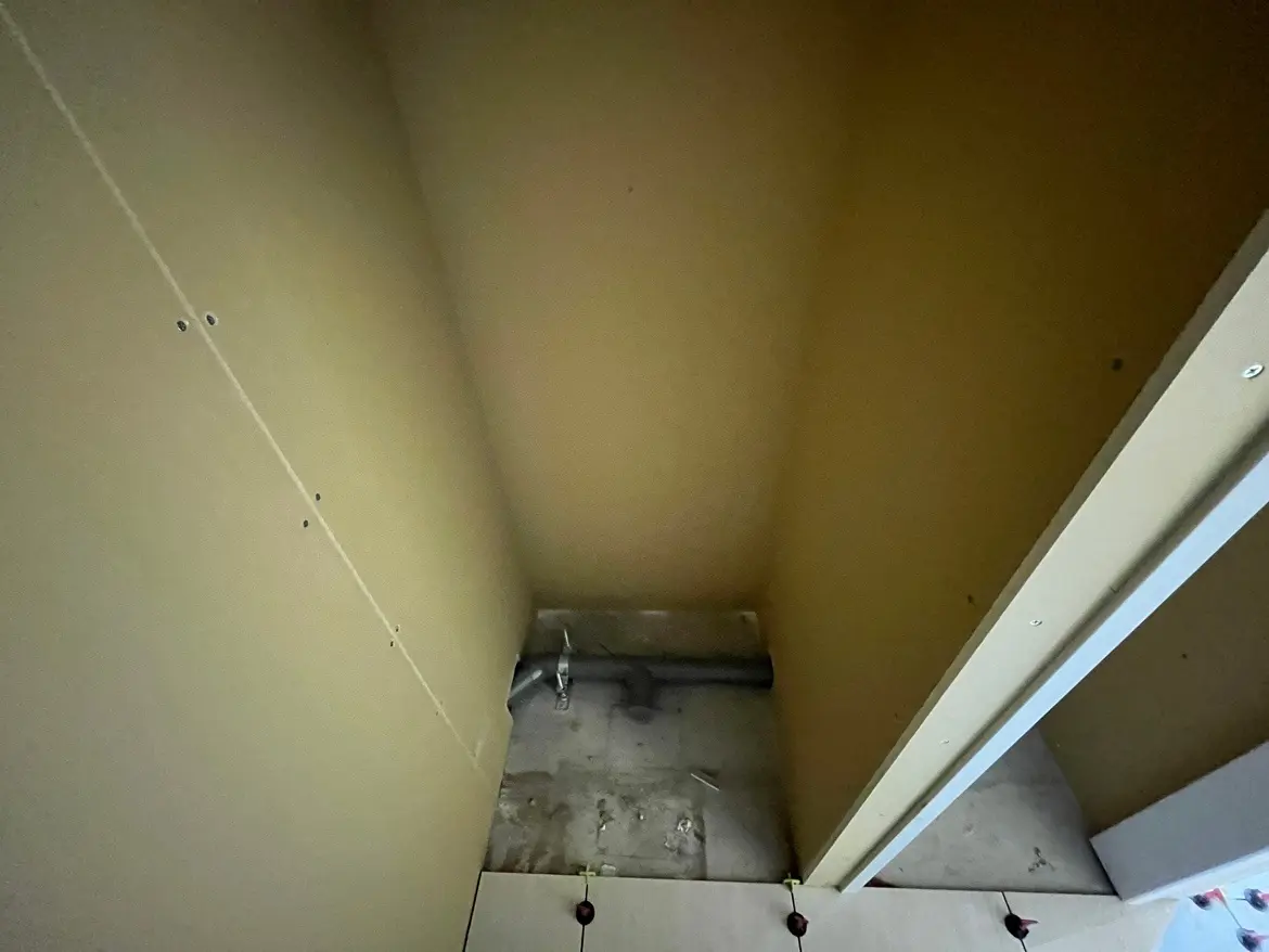 - 壁下地の施工中のクローゼット内部、未完成の状態で配管が視認できる部屋の構造