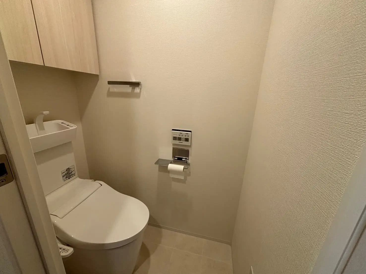 - シンプルで清潔感のあるトイレ、吊り棚と最新の洗浄機能付きトイレが配置されたインテリア
