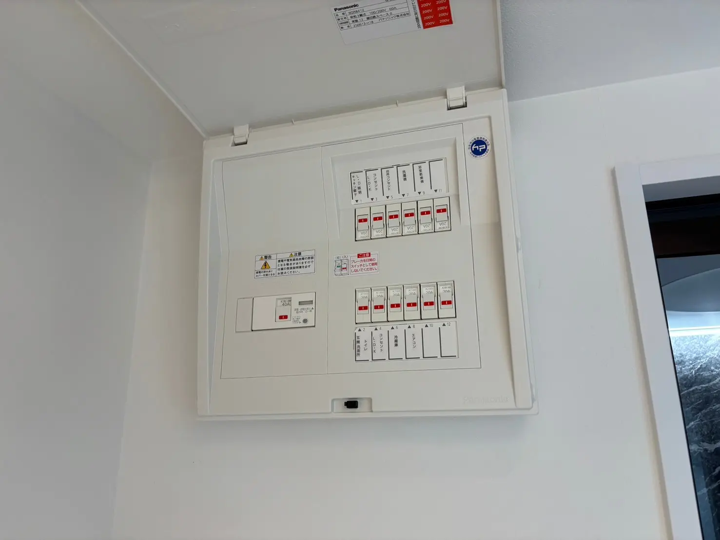 - パナソニック製の電気配電盤、スイッチやブレーカーが整然と並んでいる内部の詳細画像