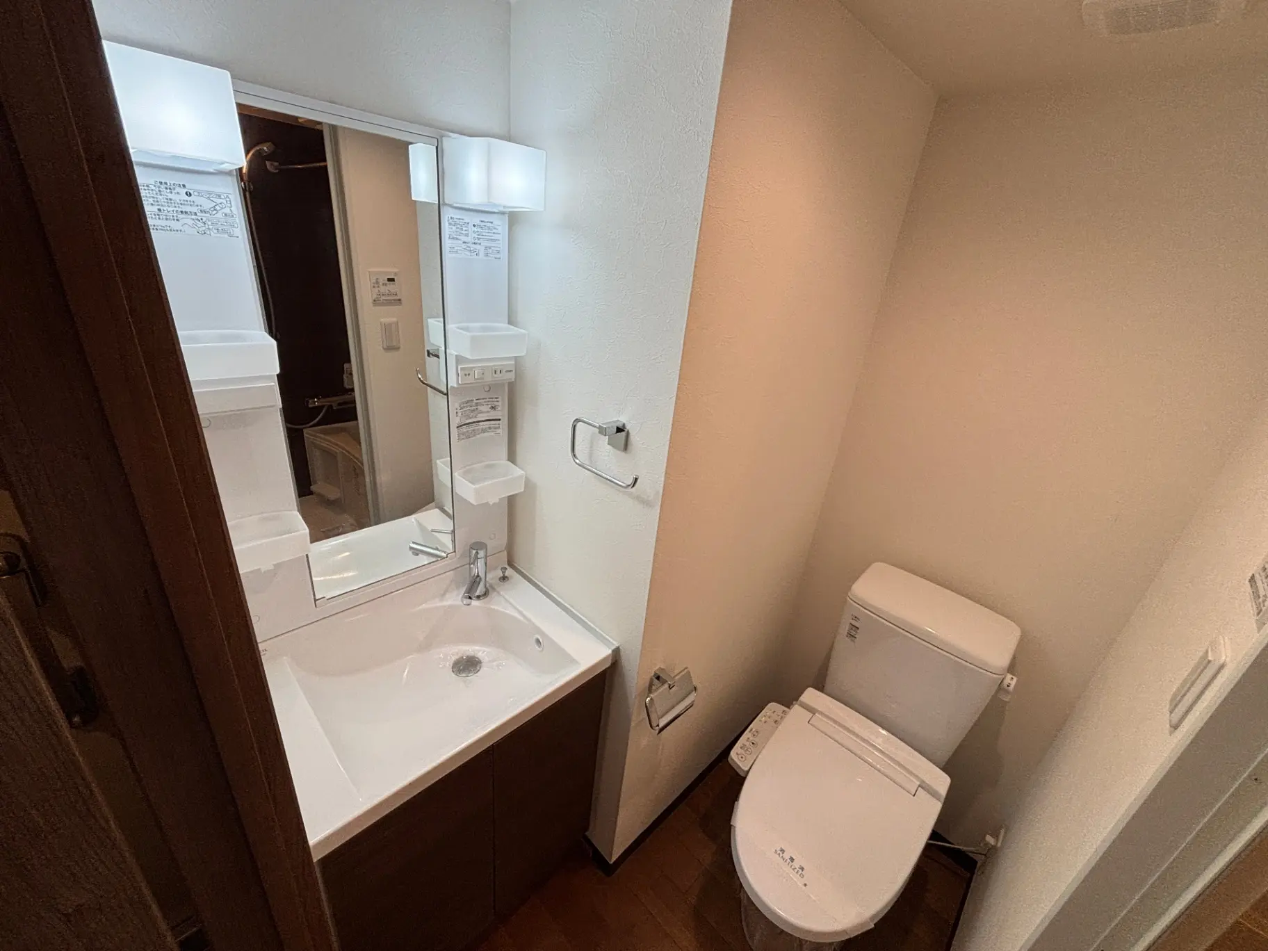 - コンパクトなバスルームのインテリア、洗面台とトイレが配置された清潔感のある空間、ミラー付きの洗面化粧台