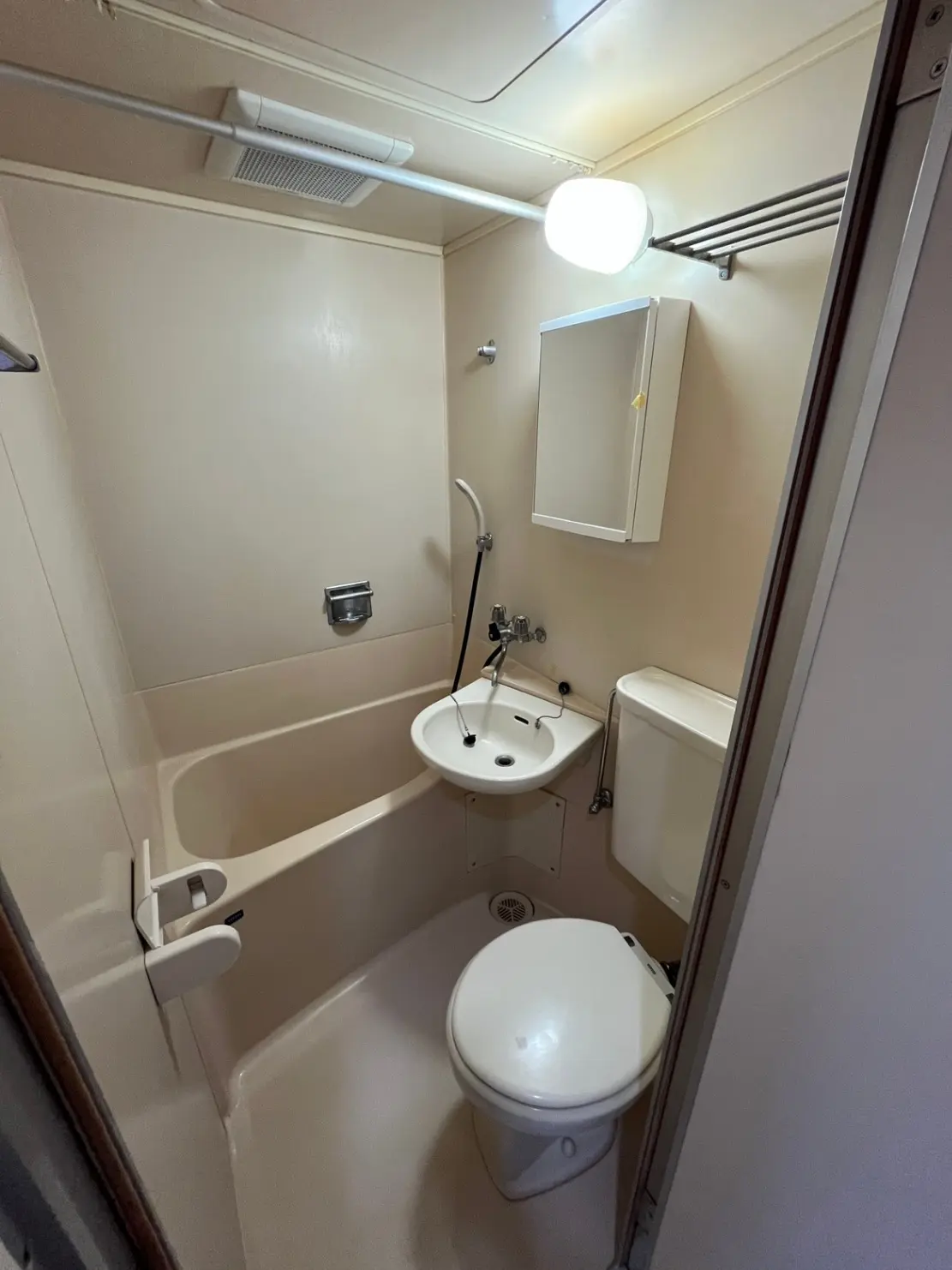 - シンプルで清潔感のあるバスルーム、浴槽、洗面台、トイレが配置されたインテリア