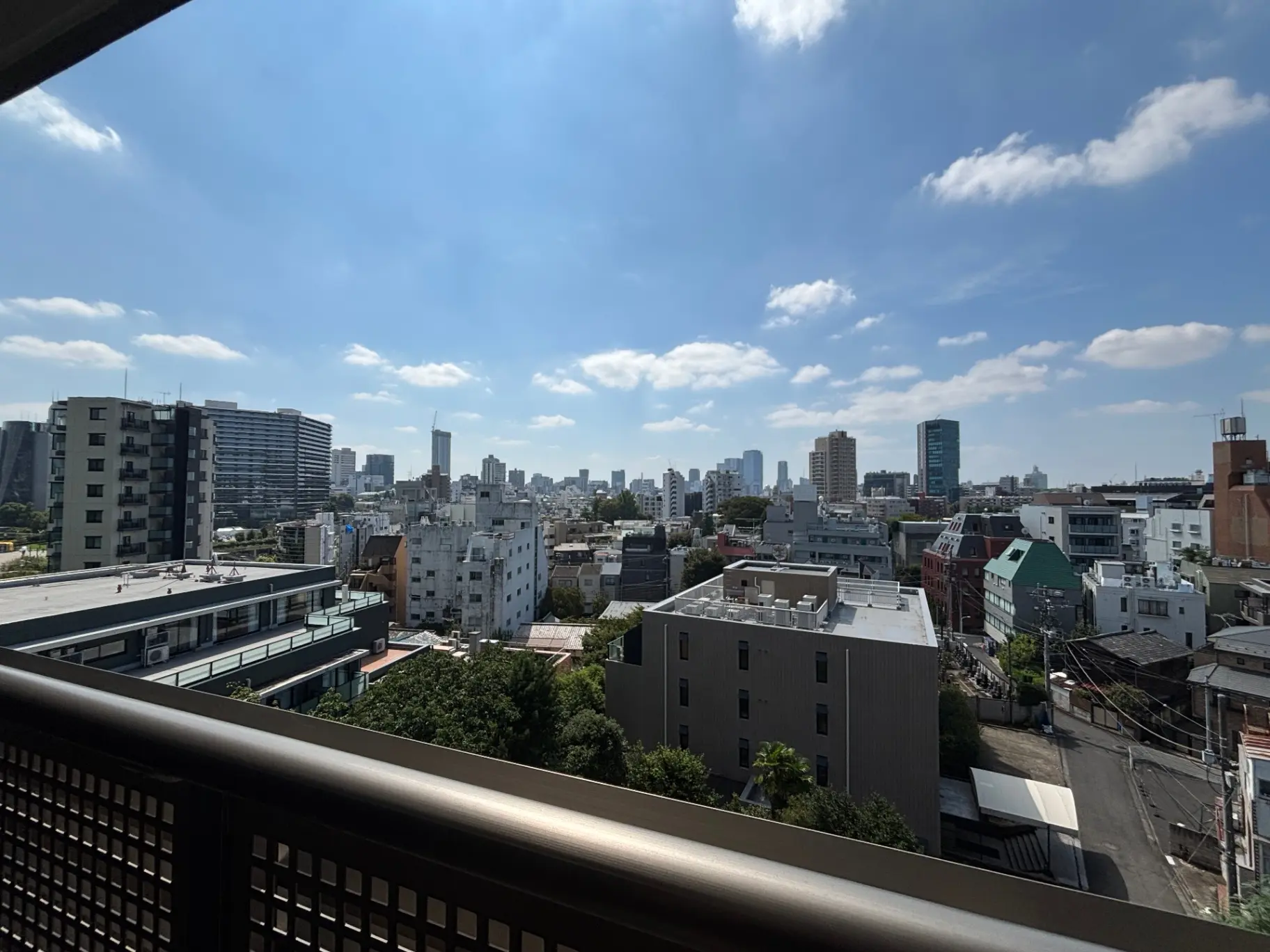 - 都市の風景、青空の下に広がるビル群と住宅、バルコニーからの眺望