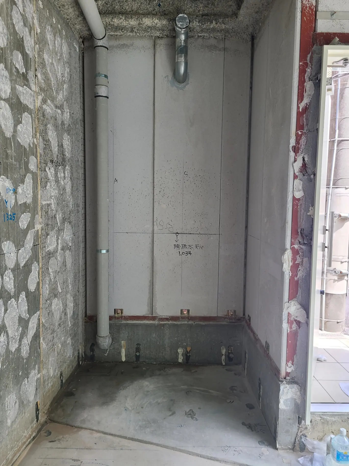建築中の部屋のコンクリート壁と床、工事現場の配管と電気配線待ちのインフラストラクチャ