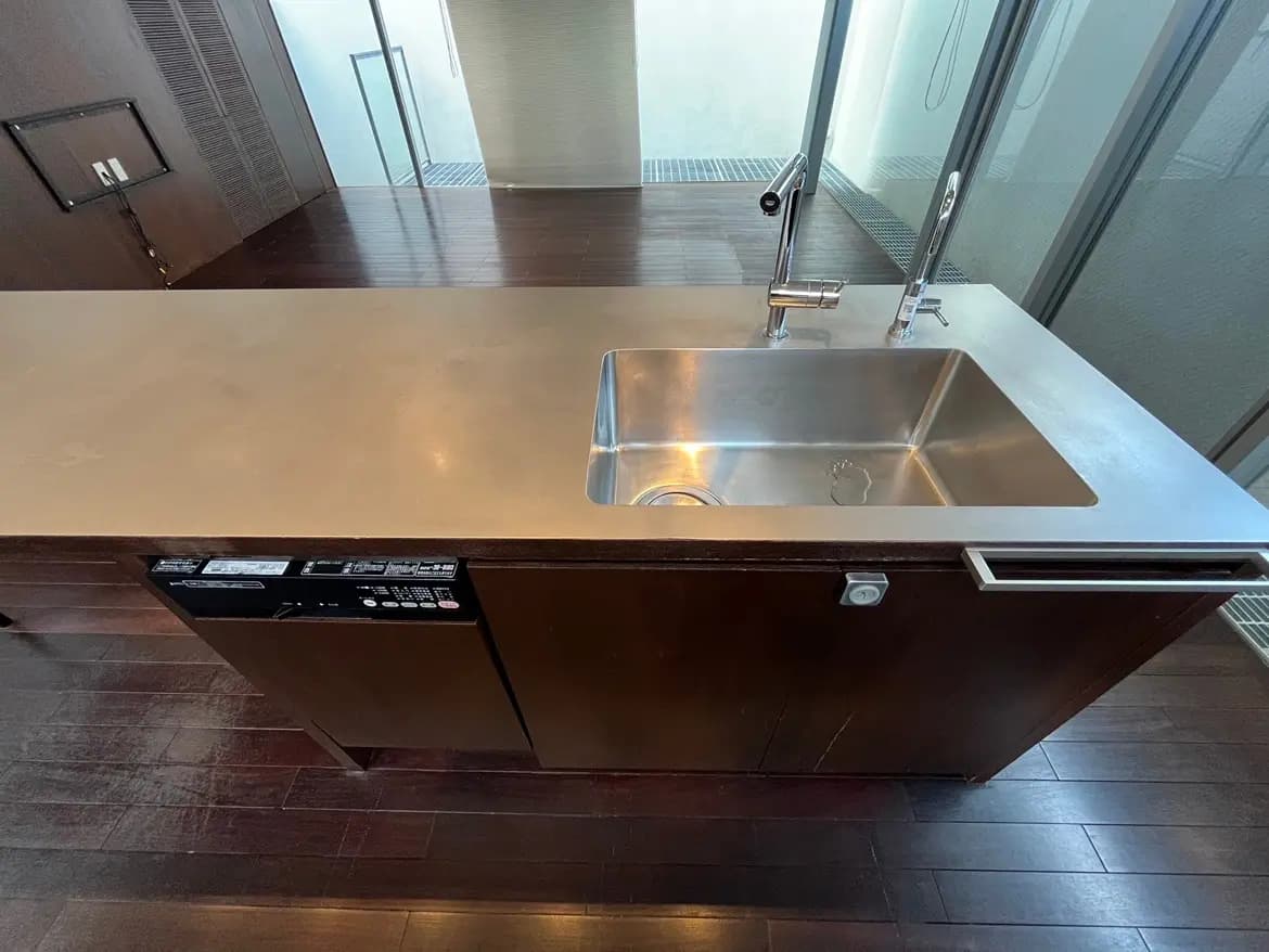 - モダンなデザインのキッチンカウンター、ステンレス製のシンクと調理器具が整ったシンプルで機能的なインテリア