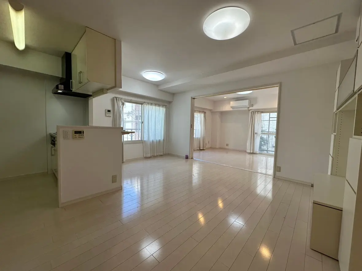 明るく広々としたリビングルーム、白いタイルフローリング、大きな窓とシンプルな照明のあるインテリア