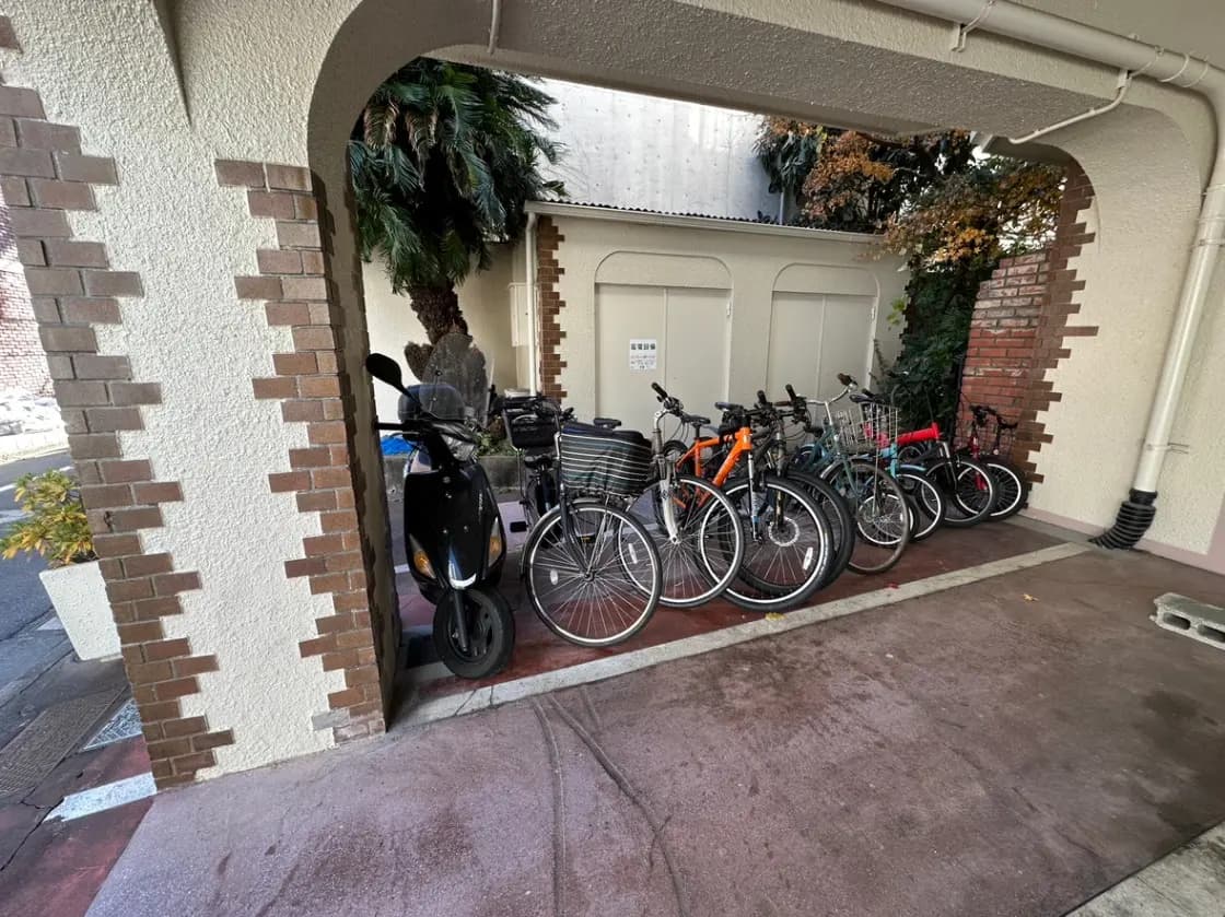 アーチ型の通路を有する建物の自転車駐輪スペース、レンガ壁とスクーター