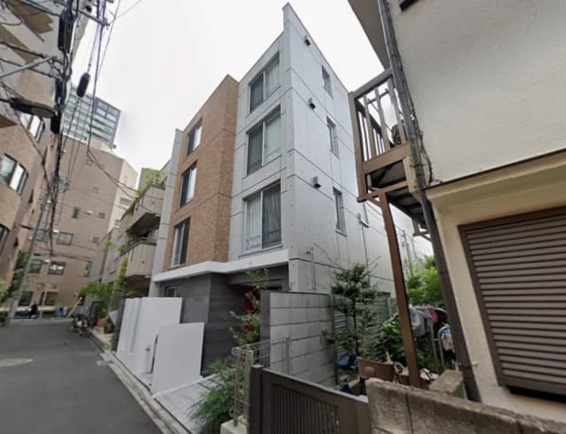 都市部のモダンなデザインの住宅街、コンクリートとレンガ造りの外観、緑植物と電線がある景観