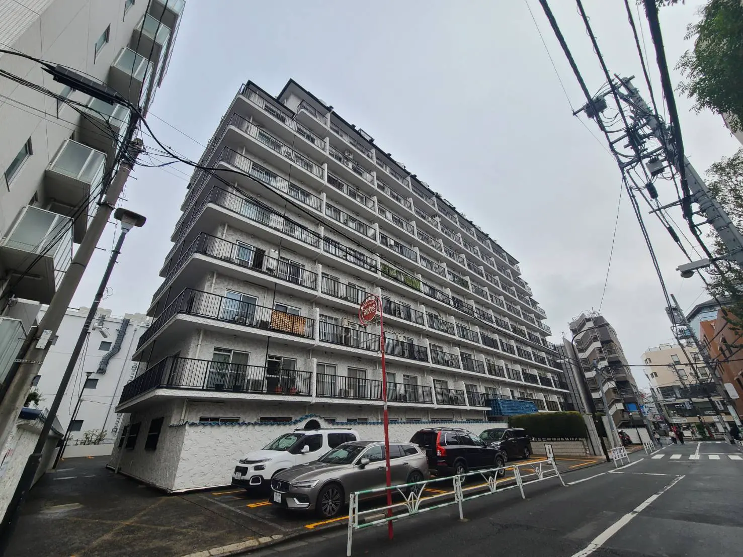 多階層のマンション外観、街中に位置し、駐車場が見える日本の住宅風景