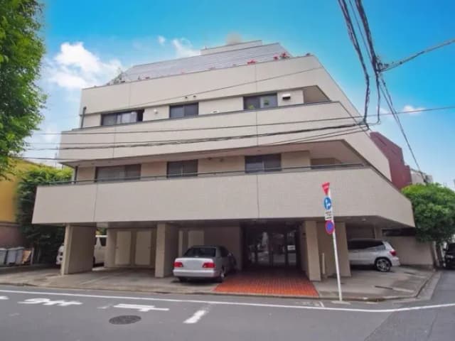 都市部にある多階層のアパート建物、屋外駐車場付き