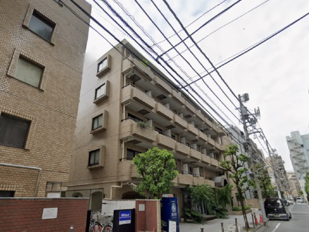 - モダンな外観の住宅、複数階建てのアパート、周囲に緑豊かな植栽と電線が見える都市の風景