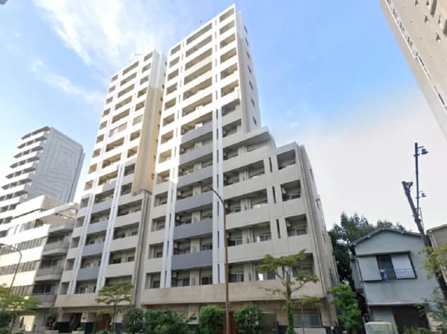 - 現代的なデザインの高層マンション、白い外壁と大きな窓が特徴的な建物の外観、近くに小さな家と緑の植物が見える風景