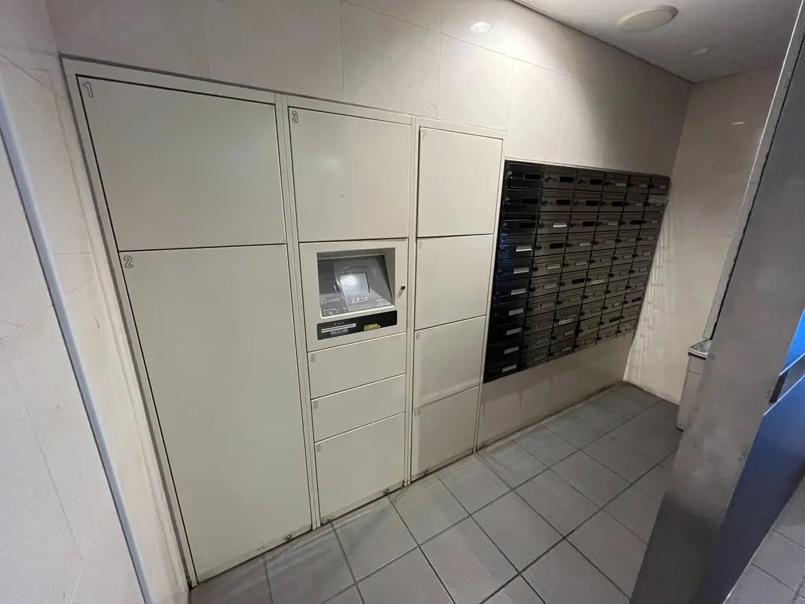 - ホテルやアパートのロビーにある郵便受けとロッカー、シンプルなデザインの壁とタイルの床