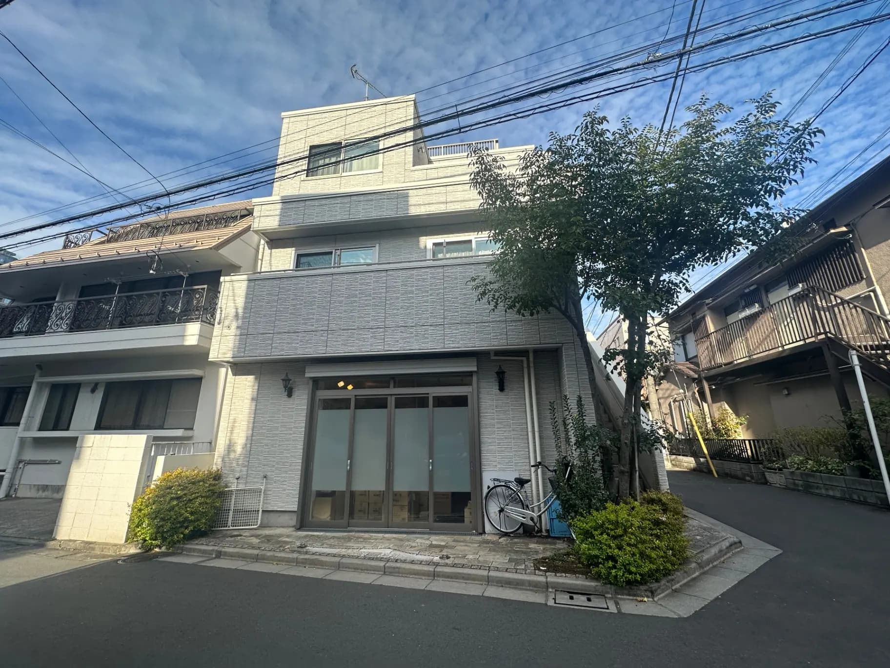 現代的な外観のアパート建物、晴れた日の青空、前に自転車が置かれた歩道