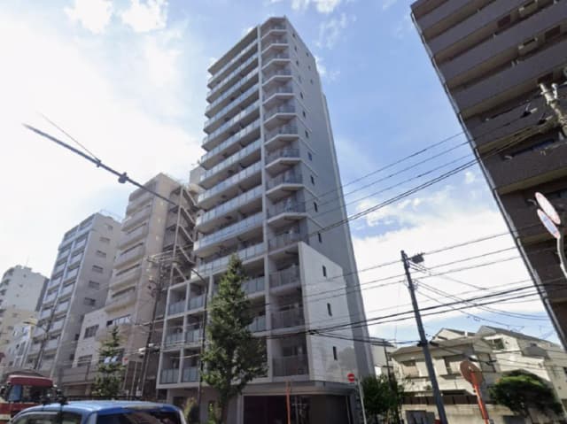 - 現代的な外観の10階建てマンション、周囲の建物や青空と共に撮影された風景